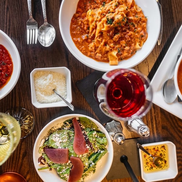 Overhead table spread of Italian dishes on a dark wooden table
